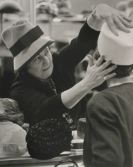 Ruth-Marion Baruch  -  Hat Woman Pressing Hat on Customer, 1961 / Silver Gelatin Print  -  11 x 14
