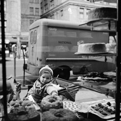 Vivian Maier  -  1954, New York NY (bakery window) / Silver Gelatin Print  -  12 x 12 (on 16x20 paper)