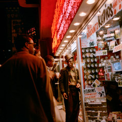 Vivian Maier  -  Location and Date unknown, (men outside store) / Chromogenic Print  -  12 x 12 on 16 x20 paper