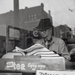 Vivian Maier  -  Chicago, 1962, (man, paper, phonebooks) / Silver Gelatin Print  -  12 x 12 (on 16x20 paper)