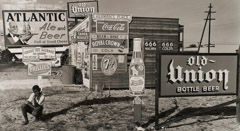 Arnold Newman  -  Billboards, West Palm Beach, FL, 1940 (boy crouching in front of signs) / Silver Gelatin Print  -  8 x 13